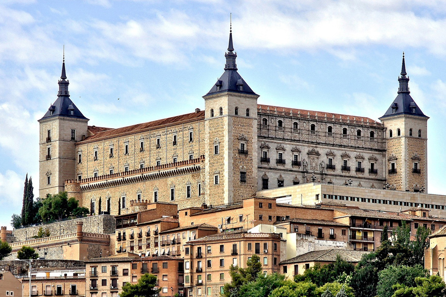 a large clock tower towering over Alcázar of Toledo