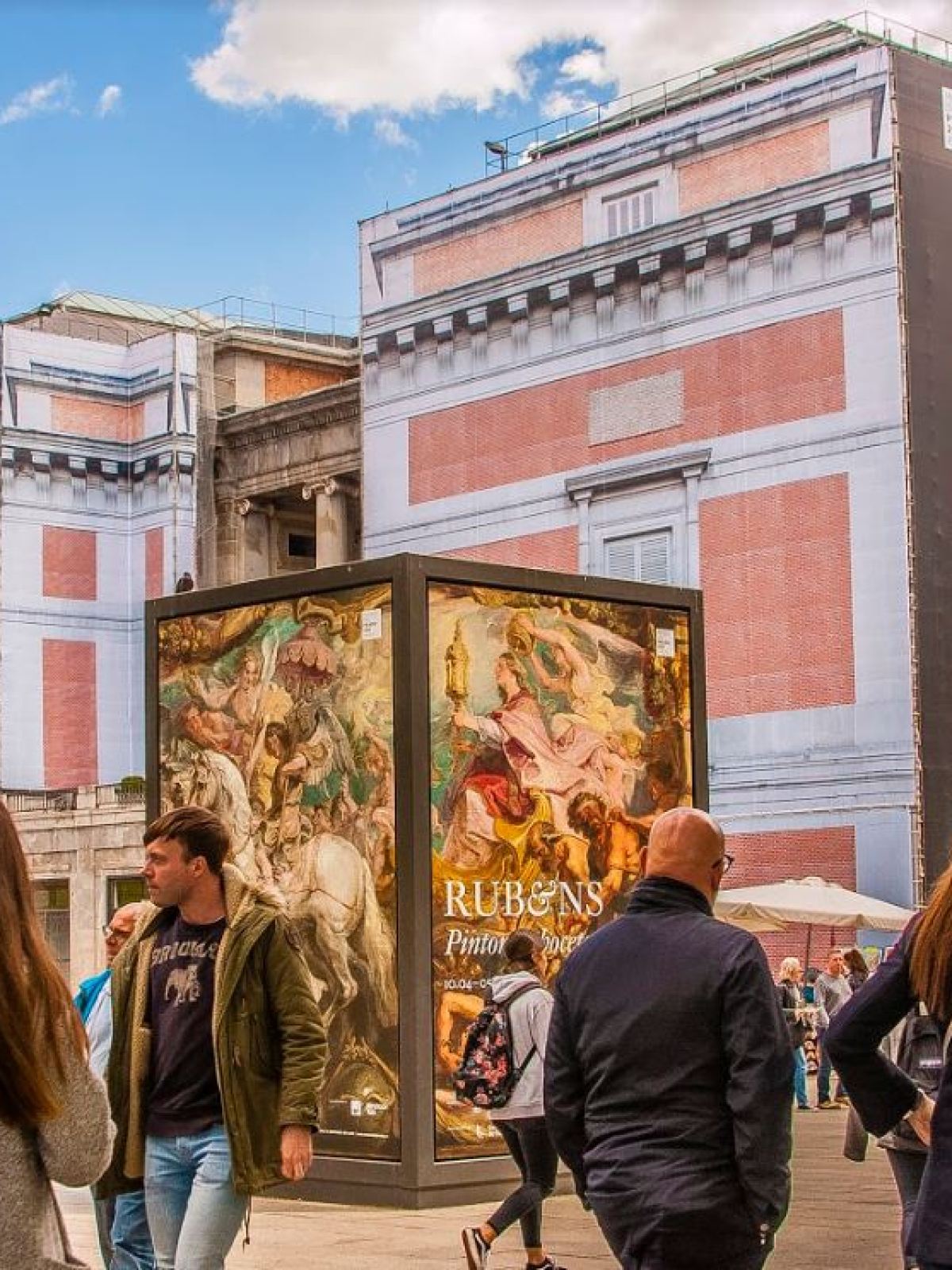 a woman standing in front of a crowd of people walking down a street