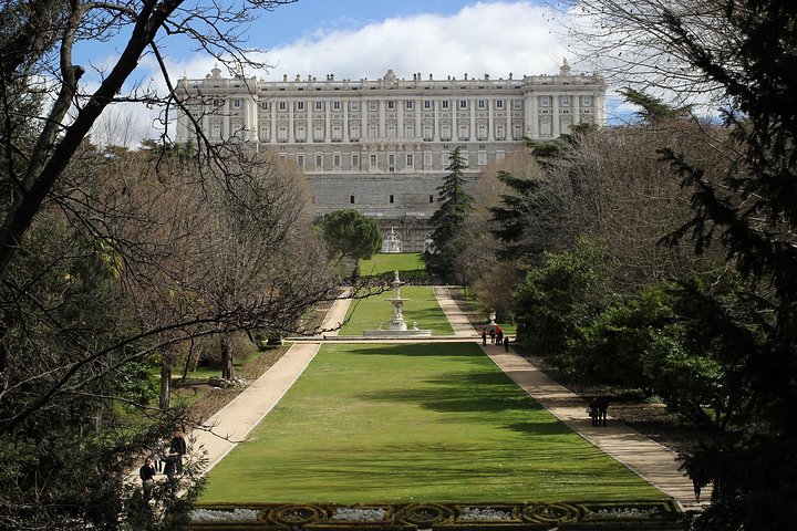 Royal Palace view from garden with path and trees on a sunny day.