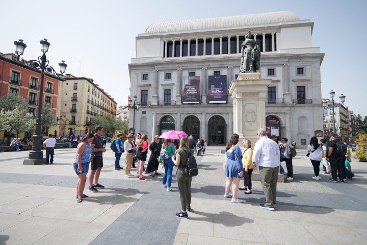 a group of people walking down a street next to a building
