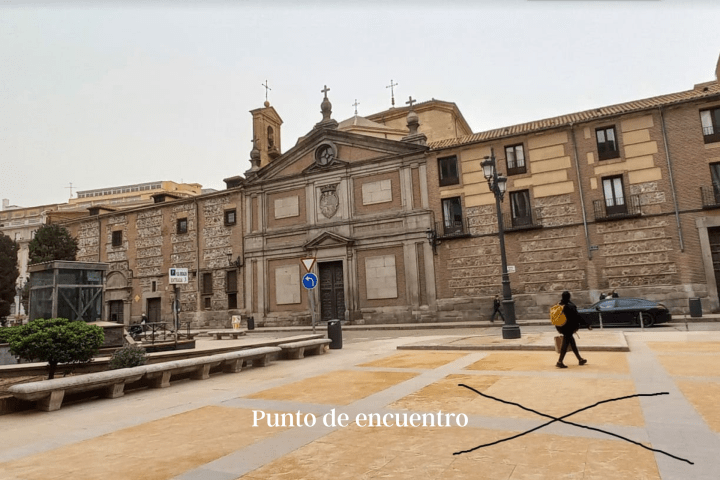 a group of people walking in front of a brick building