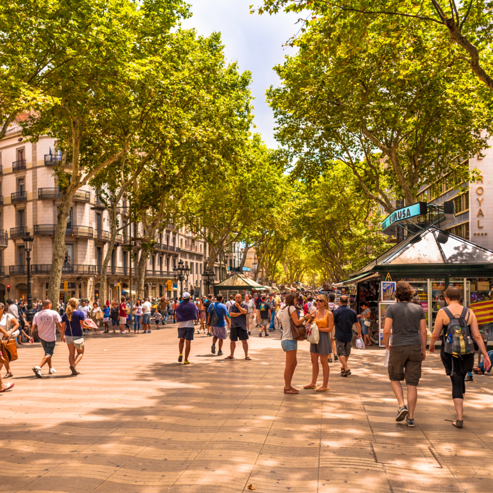 a group of people walking down the street with La Rambla, Barcelona in the background