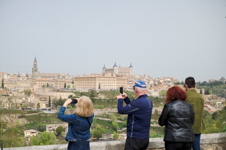 a group of people looking at a kite in front of a building