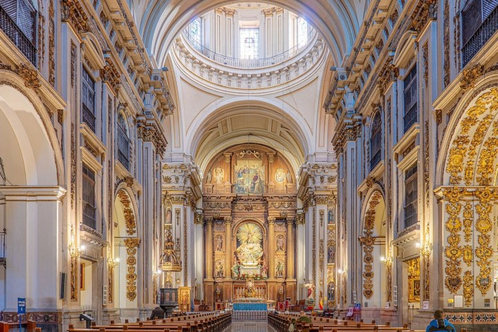 Ornate church interior with arches and decorative altar.